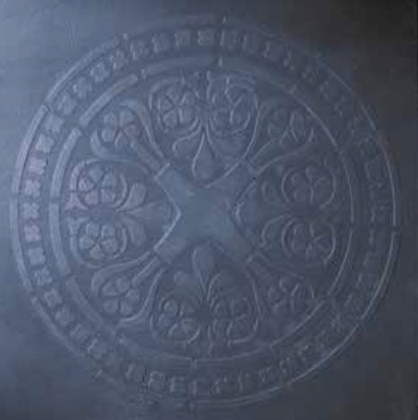 Decorative circular emblem stencil with intricate patterns on a dark background